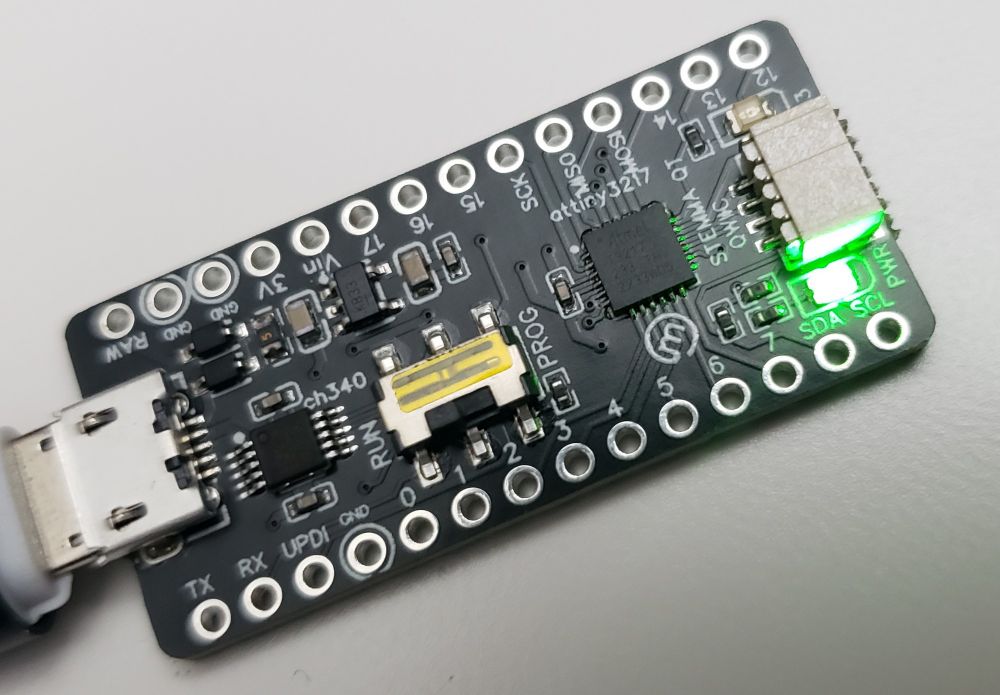 A small printed circuit board with a USB micro jack, a ch340 ic, a switch, an attiny3217 ic, and a 4 pin just connector.