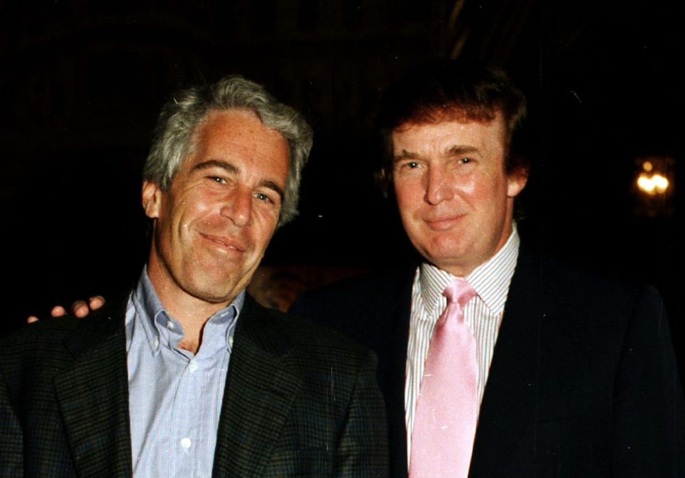 Epstein on the left, Trump on the right. Both are smiling for the camera and dressed in suit jackets.