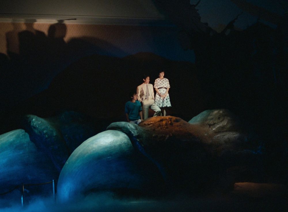 Yasuko Sawaguchi, Ken Tanaka and Shin Takuma standing on a giant Godzilla foot prop