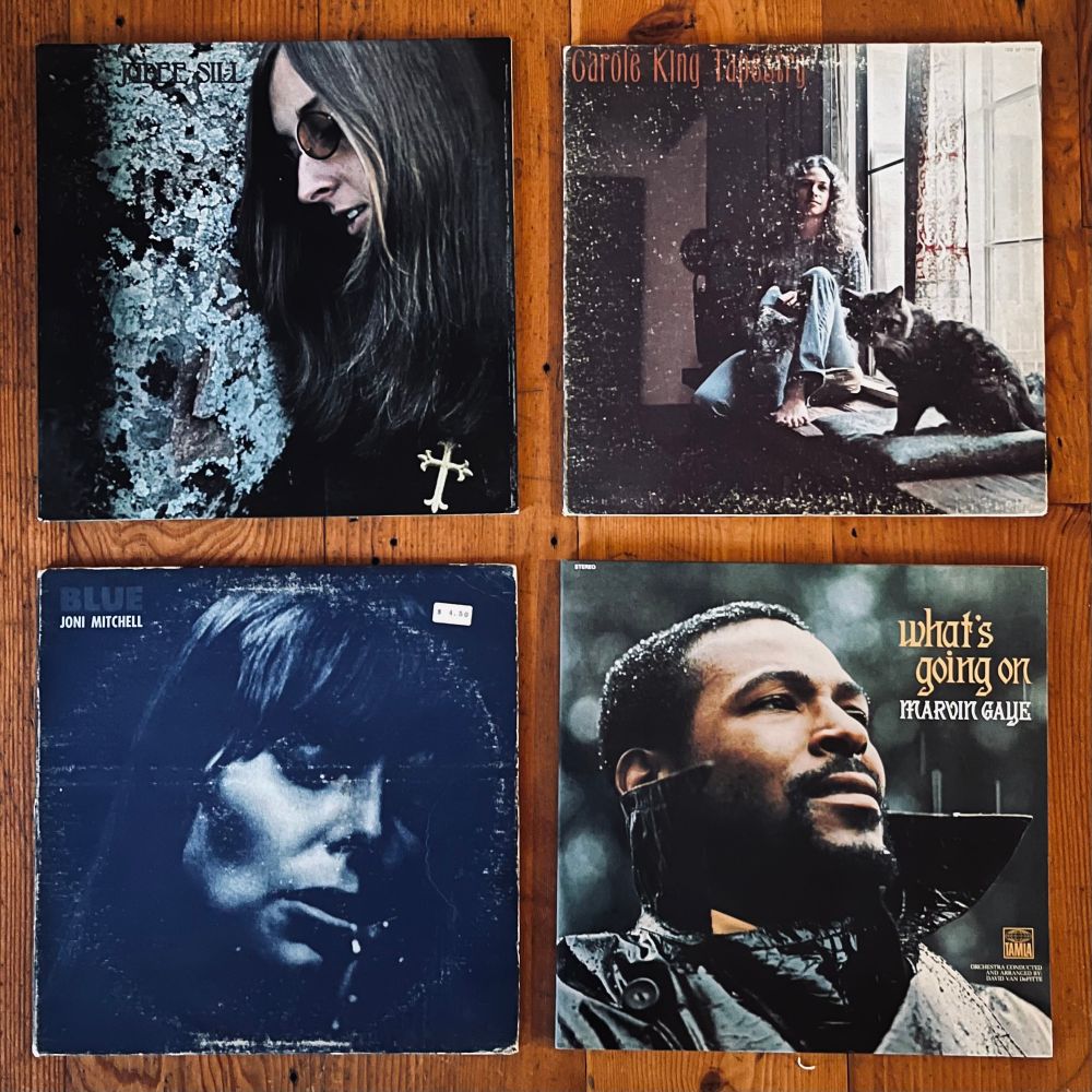 Vinyl copies of Jude Sill’s eponymous album Tapestry by Carole King, Blue by Joni Mitchell, and What’s Going On by Marvin Gaye