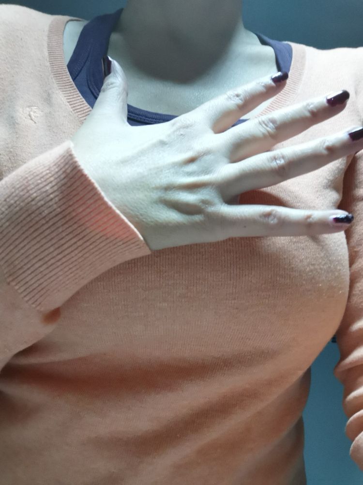 Halte meine ausgestreckten Finger/ Hand über einen apricotfarbenen Pulli 