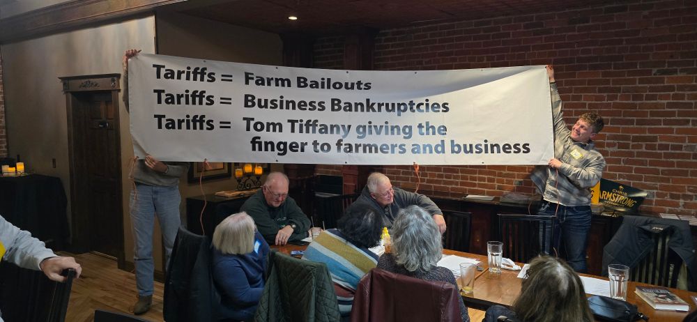 Banner:
Tariffs = Farm Bailouts
Tariffs = Business Bankrupties
Tariffs = Tom Tiffany giving the finger to farmers and business 