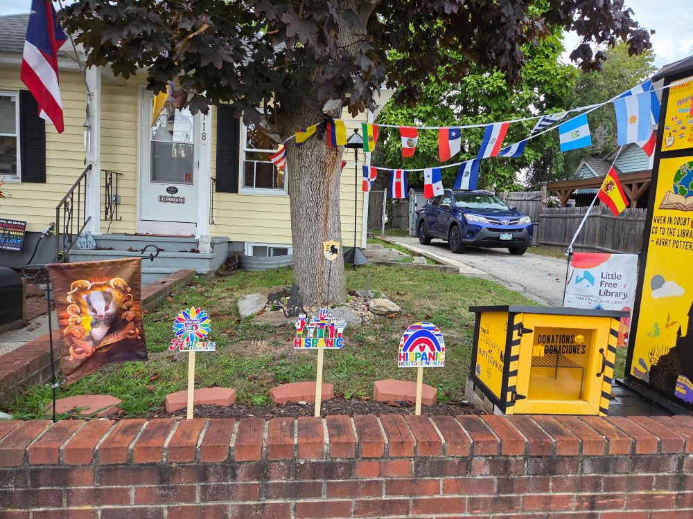 The front yard with lawn signs that says Hispanic Heritage month.