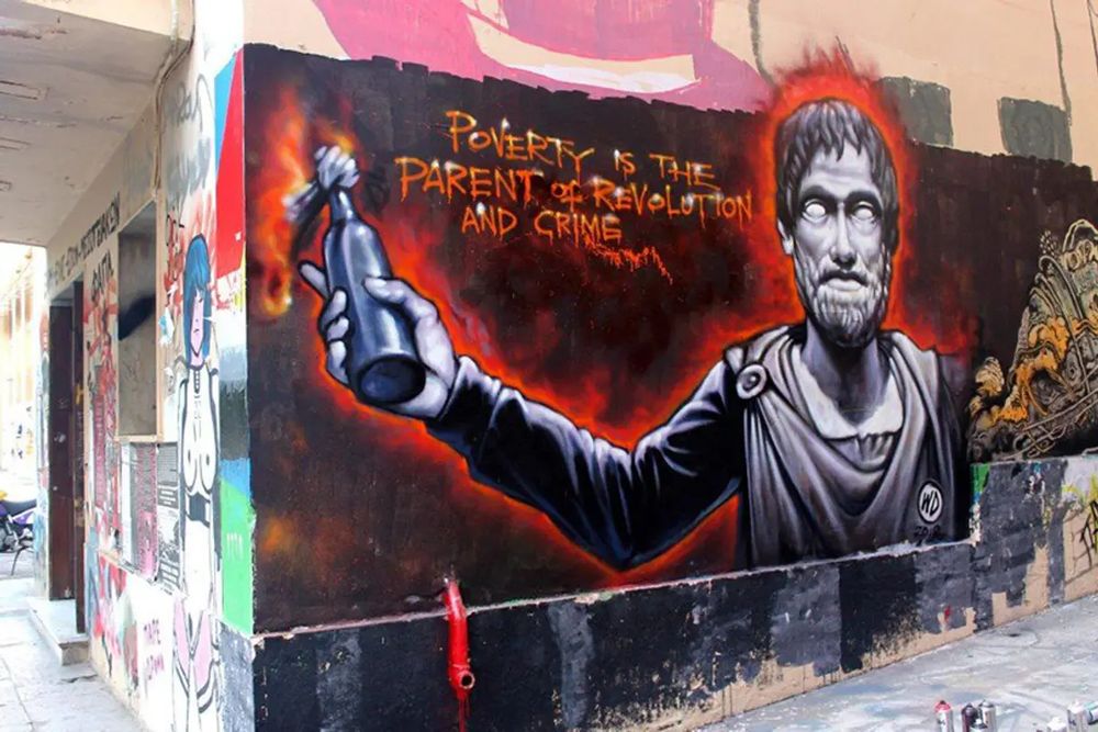 A mural in Greece depicting Aristotle with a molotov cocktail and the phrase "Poverty is the parent of revolution and crime." 