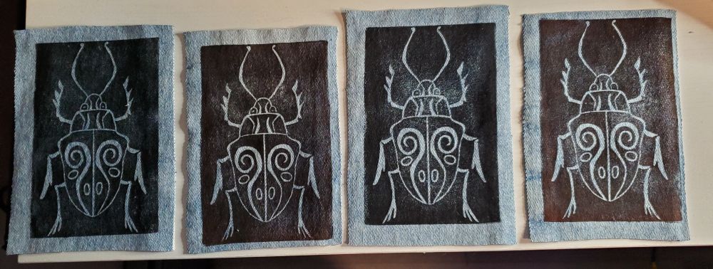 Patches on light blue denim of a whimsical beetle 