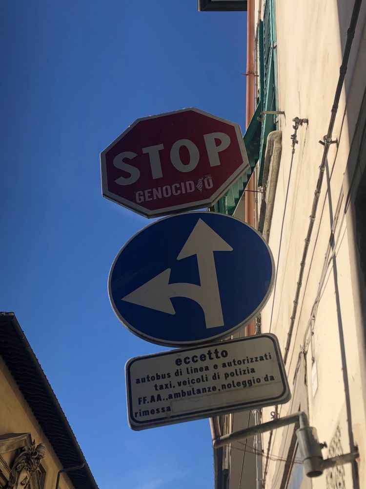 Foto på en italiensk stoppskylt för bilar där någon har lagt till ordet ”genecidio” under ”STOP”