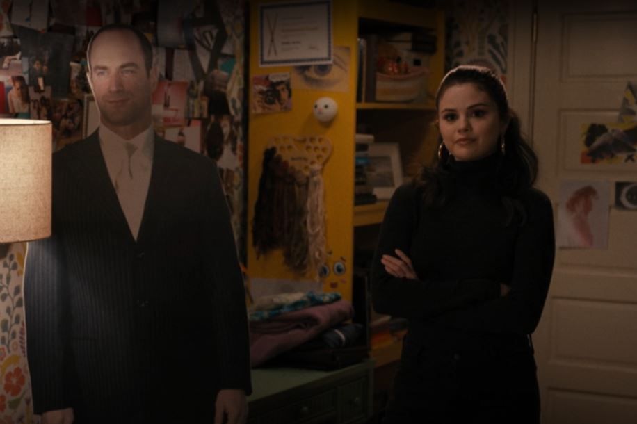 Mabel from Only Murders in the Building standing next to a cardboard cutout of Christopher Meloni, probably as Eliot Stabler from Law and Order SVU