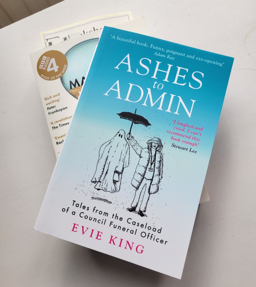 Newly delivered paperback of Ashes to Admin - Tales from the caseload of a council funeral officer. Sat on top of Ed Conway's Material World.