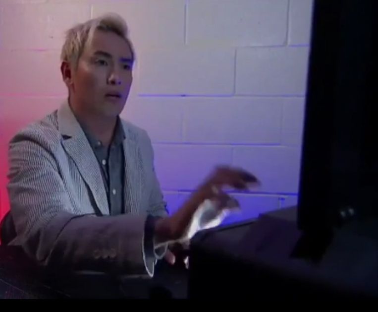 Kazuchika Okada pressing buttons on a computer.
