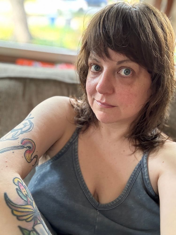 A selfie of Blue with freshly washed hair, wearing a blue jumpsuit 