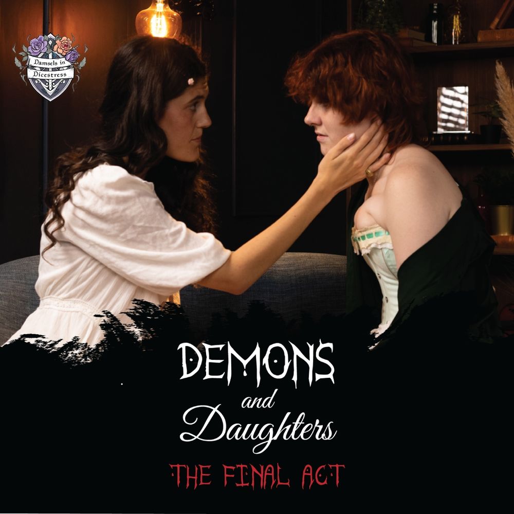 Taya as Rosalind, in a frilly white robe and rose hairpins, leaning forward to touch Maijai's face. Maijai, as Thalia, is in a green corset and silky green shirt, looking sadly back at her. Demons and Daughters white text logo on black splash. 