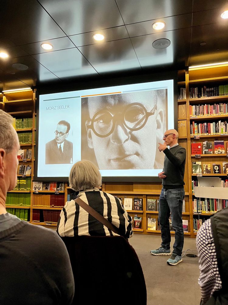 A photo of myself (a middle-aged guy wearing glasses) presenting in the BFI library, with a screen in the background.