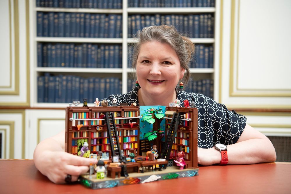 Teresa Elmore, exhibition contributor, sits with her lego model, 'Idea of a Library'