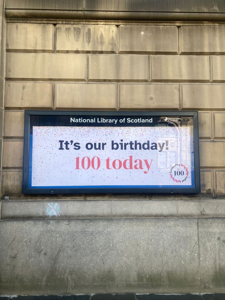 A sign reading ‘It’s our birthday! 100 today’ in front of the National Library of Scotland building in Edinburgh.
