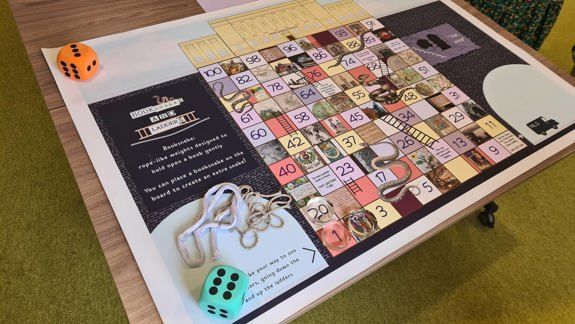 A library themed snakes and ladder games on a table.