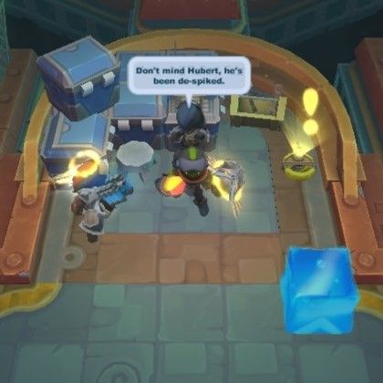 A screenshot of the PC game, "Spiral Knights", featuring a blue gelatinous cube. Three knights in various armors are standing near a console, while the cube rests a few paces away. One of the knights, evidently an NPC, has a speech bubble reading: "Don't mind Hubert, he's been de-spiked." ("Jelly Cubes" in Spiral Knights grow spikes and fangs along their edges as the game progresses in difficulty.)