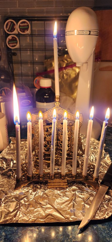 Chanukiah with 8 candles and the shamesh lit.