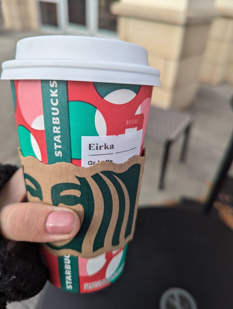 My hand holding a grande latte cup. My nails are painted pink. The label says Eirka, which even phonetically I don't think makes sense. 
