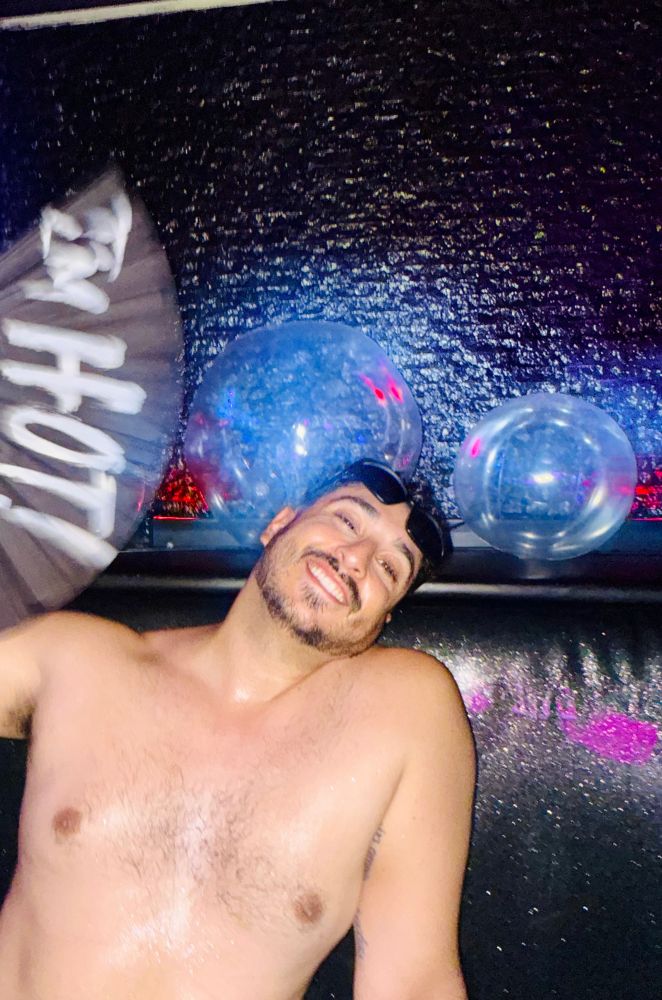 Me fanning my sweaty shirtless torso with a hand fan that reads Hot! I had just made out with three guys prior to this photo being taken 