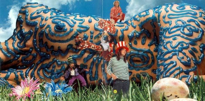 an extended version of the album art to jellyfish's "spilt milk", taken from the booklet included in its cd release. it depicts the band members stood on and in front of a large, nude figure