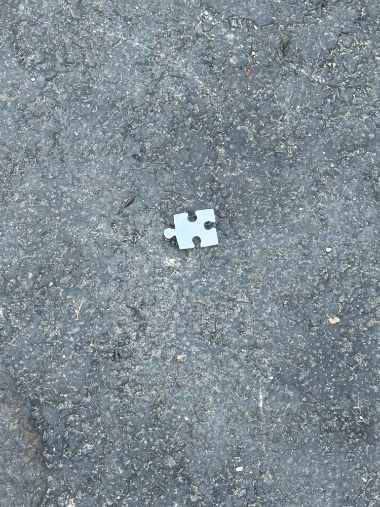 One jigsaw puzzle piece on the asphalt 