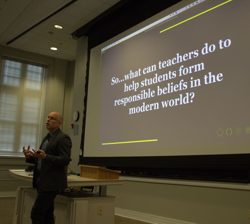 Jeff Greene standing in front of a slide that reads: "So...what can teachers do to help students form responsible beliefs in the modern world?"