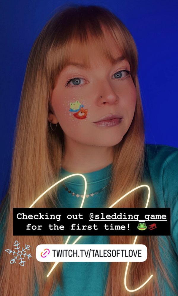 Tiffany softly smiles in selfie with bodypaint of two Sledding Game characters on your cheek. 