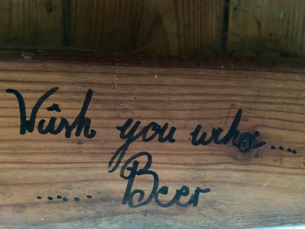 someone scribbled "Wish you were .... beer" in a hut which is cringe but also funny because it is cringe