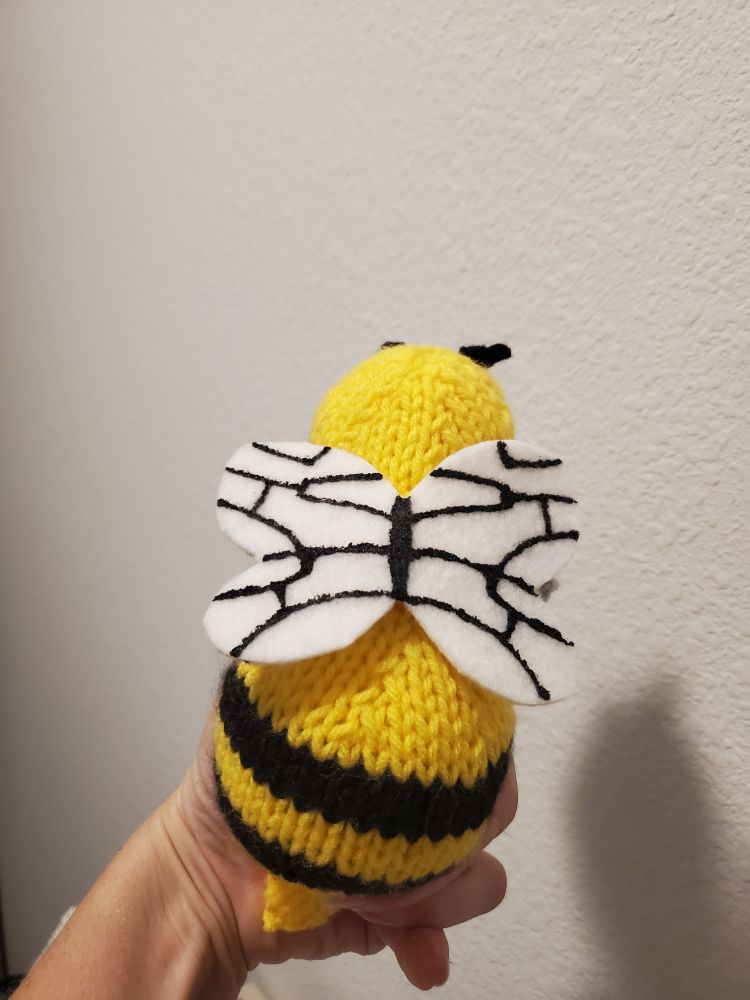 A top down view of a knitted Beedrill plushie, showing off the wing pattern