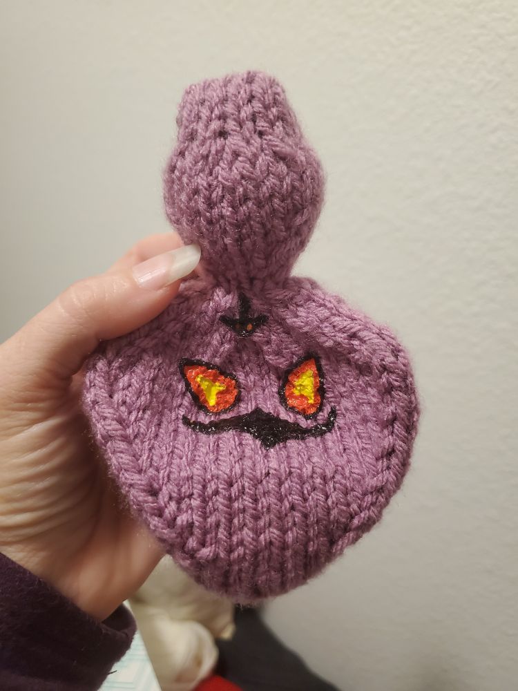 The Arbok plushie with the head lifted to show off the hood design, which was drawn on free-hand with fabric paint.