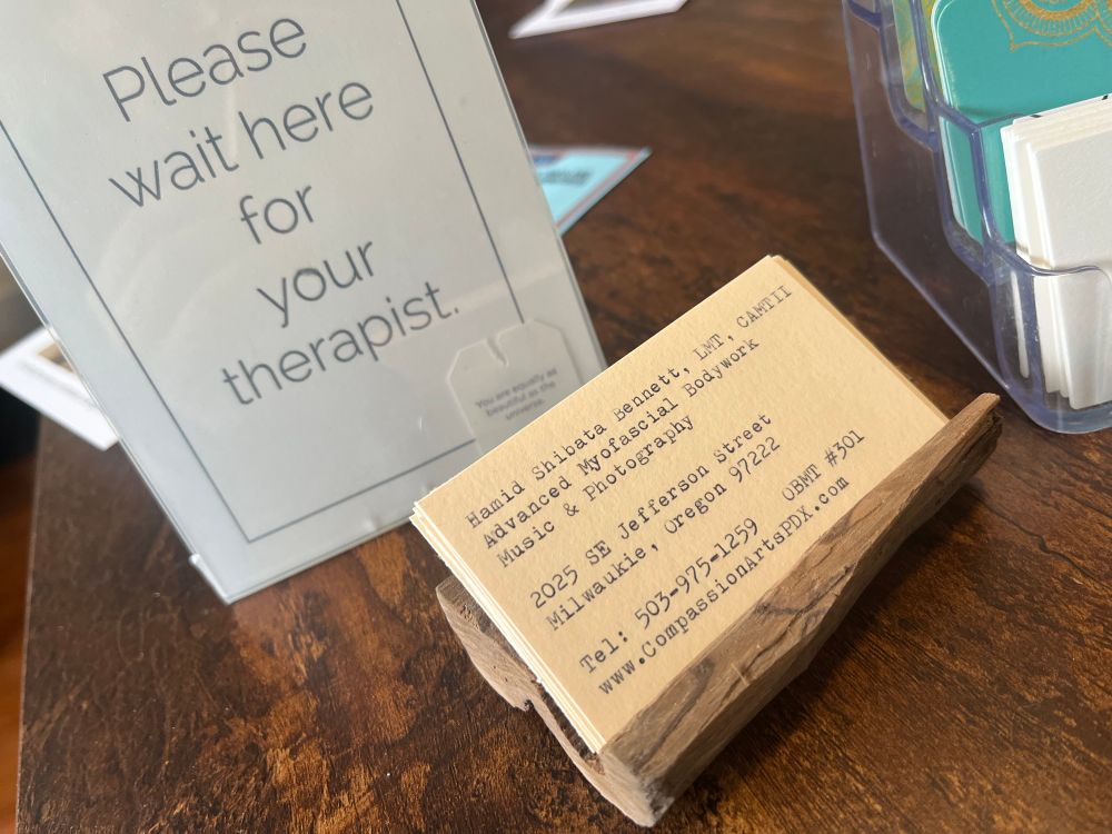 Hamid’s cards on another, more simple bushcraft card holder, next to a sign that reads, “Wait here for your therapist”