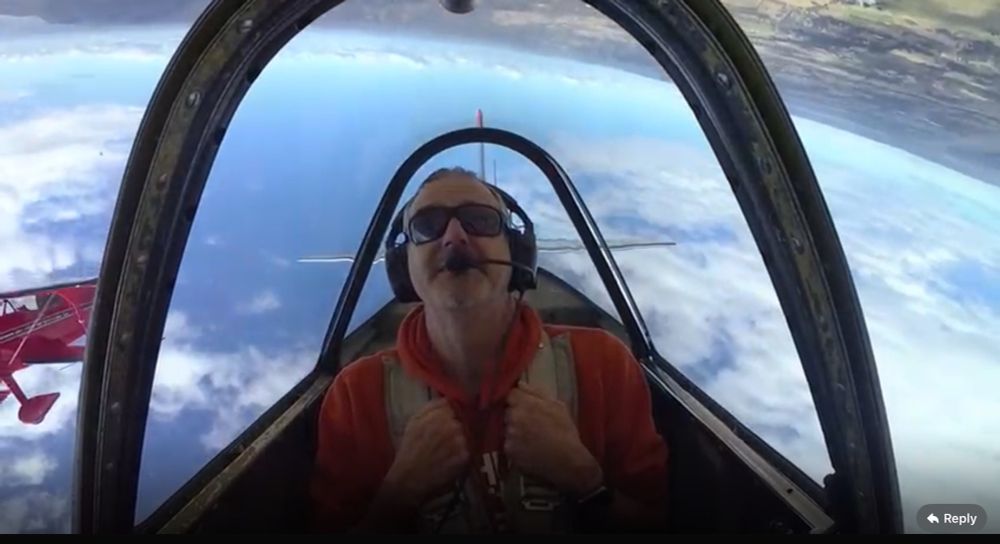 Poster in an inverted Yak aircraft with a red Pitts special aerobatic plane in formation 