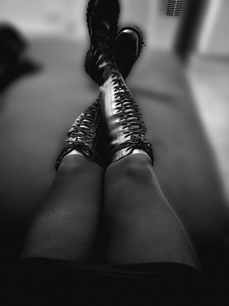 Ich in nicht binärer Kleidung mit overknee Stiefeln. Bild  im sitzen mit ausgestreckten und übereinander geschlagenen Beinen