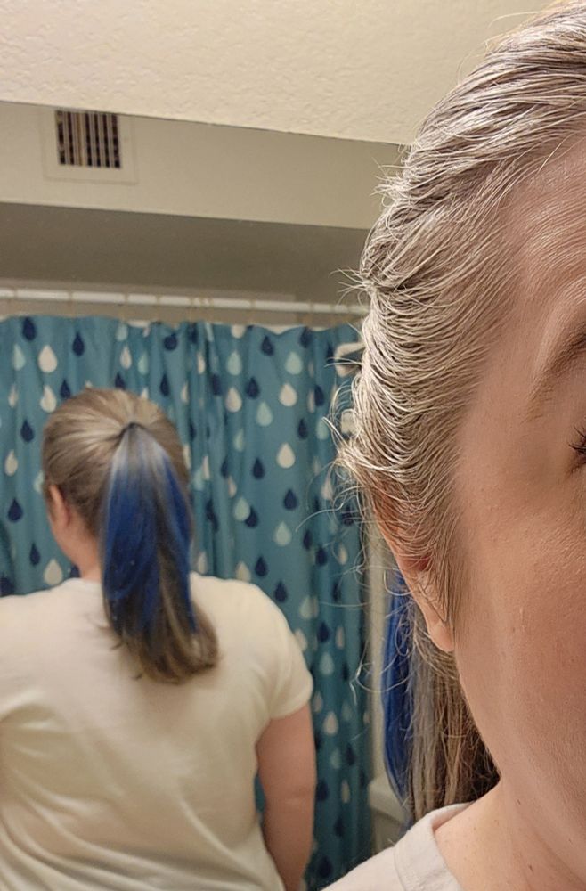A mirror selfie of the back of my head. The top layer of my ponytail is royal blue. The shower curtain is from the Target pillow fort collection from several years ago. 