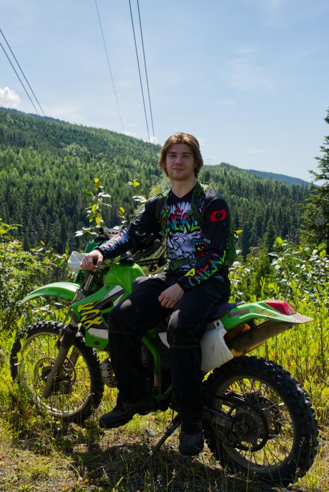 Ricky poses with his KDX220. Powerlines and mountains in the background.