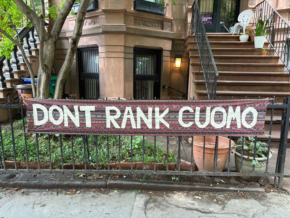 A textile banner on a fence that reads: Don’t Rank Cuomo