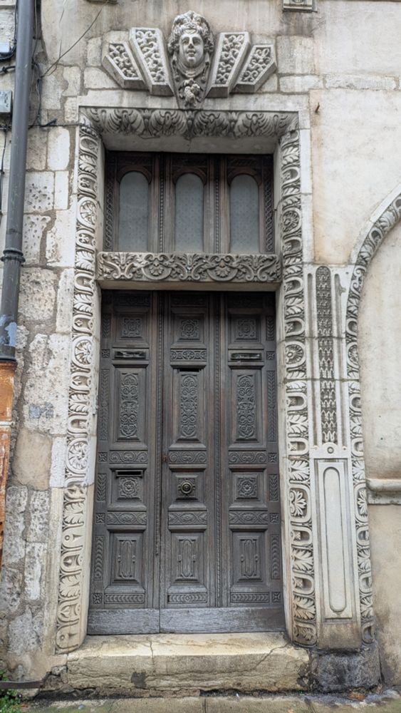 Porte d'une maison de Beaune encadrée de pierres blanches sculptées et rehaussée d'une tête de Bacchus, dirait-on. 