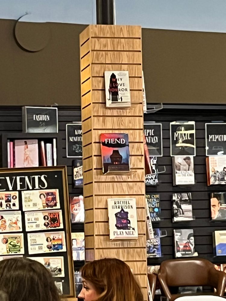 Pillar with books displayed. From top down— AHY I LOVE HORROR by Becky Siegel Spratford, FIEND by Alma Katsu, and PLAY NICE by Rachel Harrison. 
