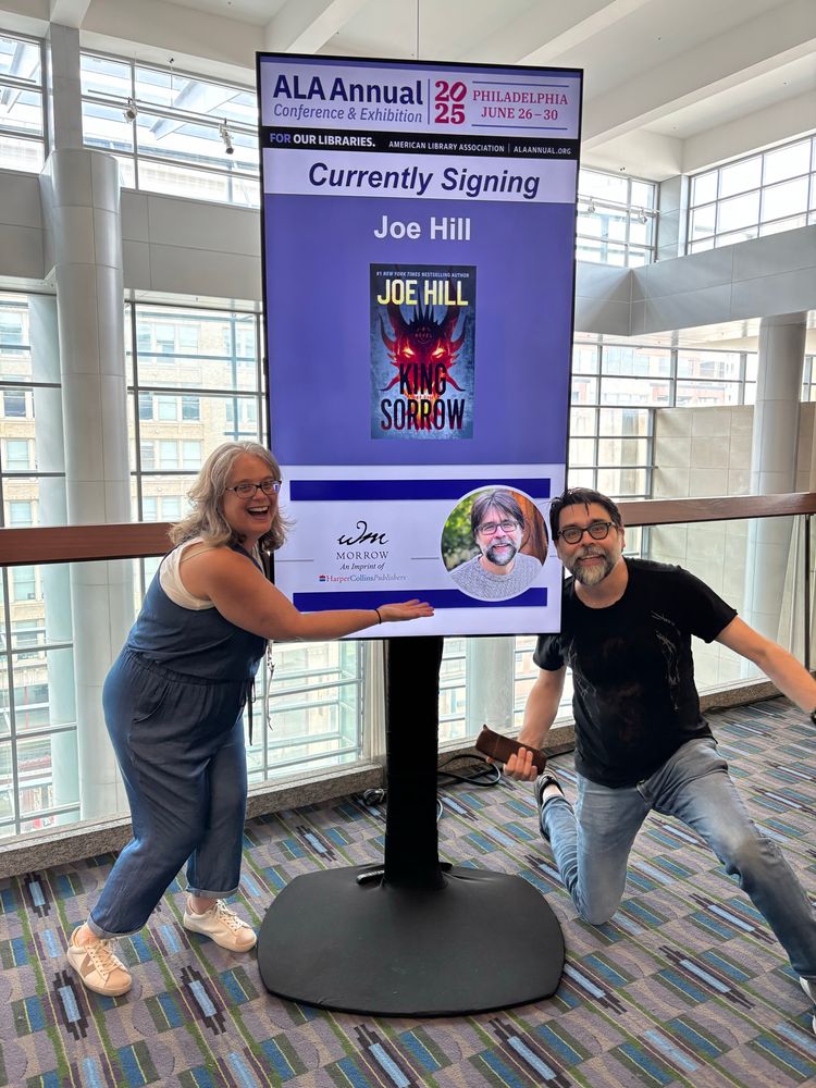 Becky and Joe in front of the sign advertising his signing after the crowds were gone