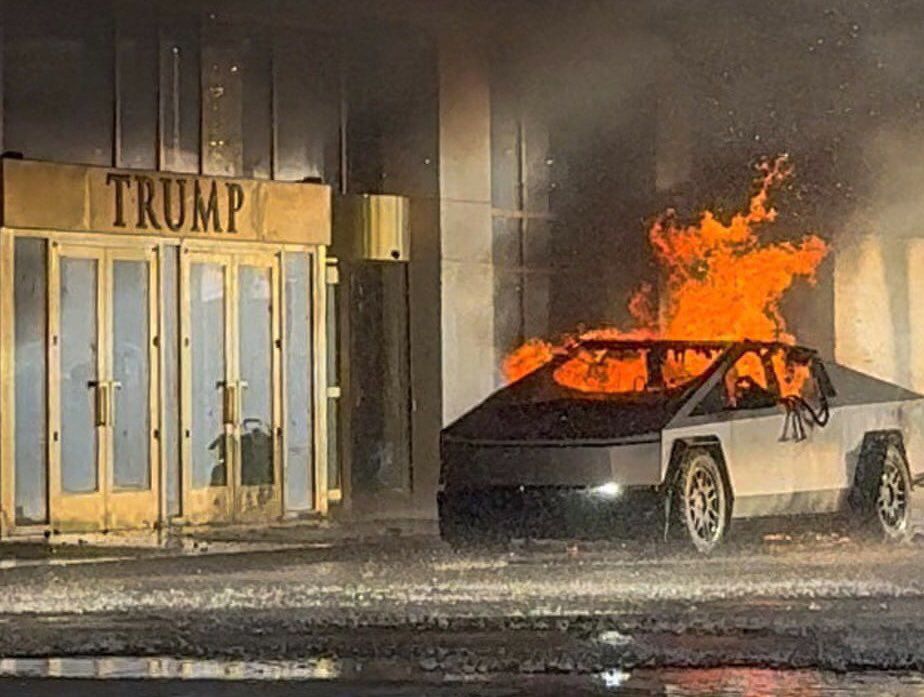 A clown car on fire in front of a circus building