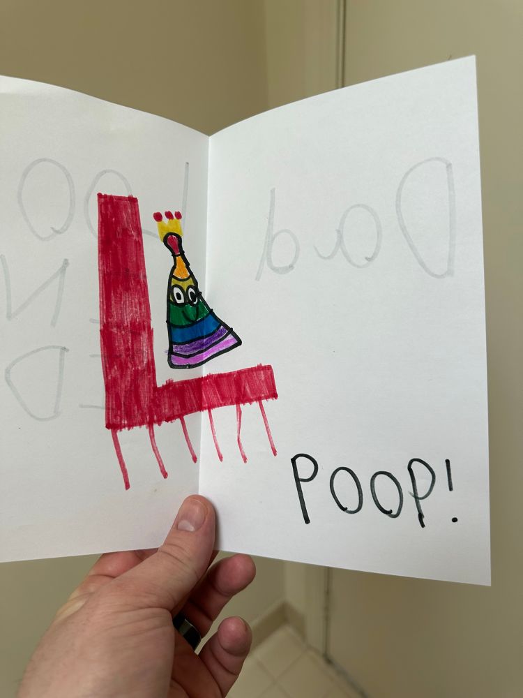 A children’s drawing of a rainbow poop with the word “POOP!”