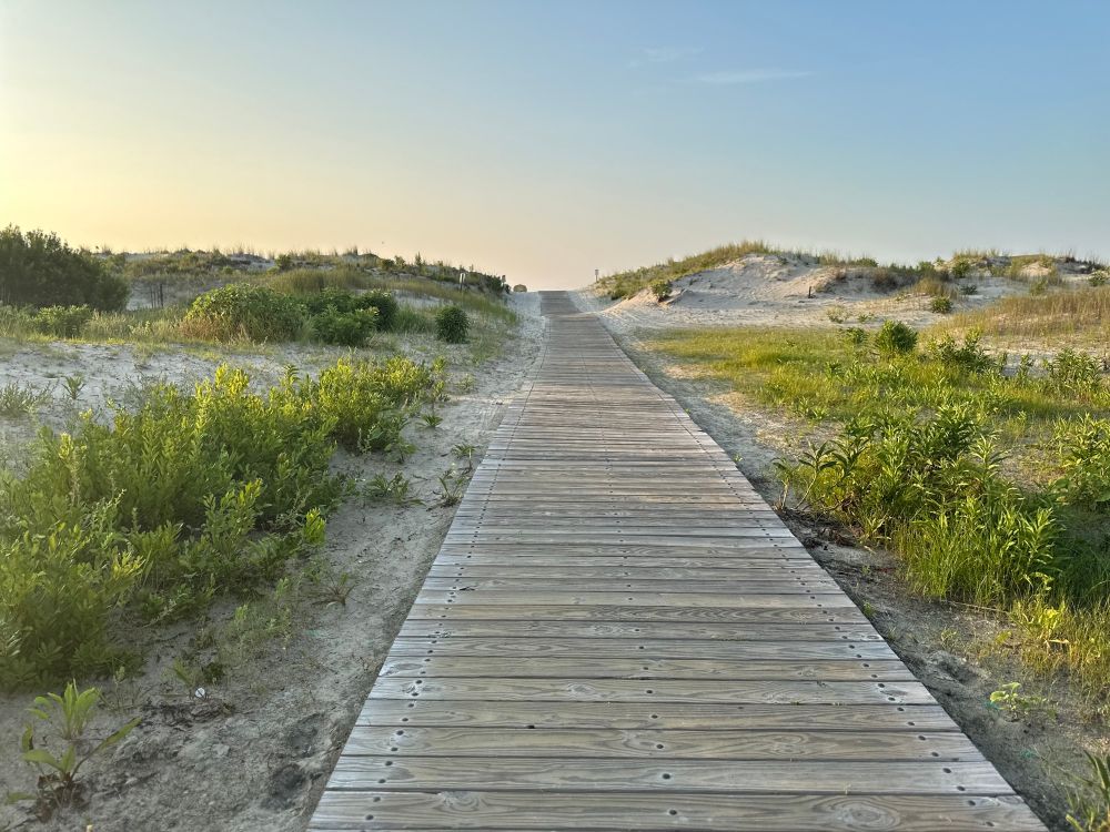 A photo of a boardwalk leading to the ocean