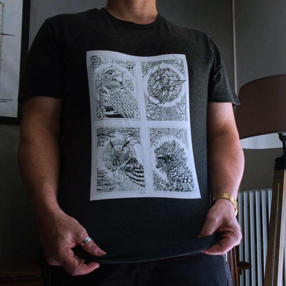 Photo d'une personne portant un t-shirt floqué de 4 dessins d'oiseaux dans un style art nouveau/steampunk. 1 une buse entourée d'engrenage 2 un colibri entouré de fleurs 3 un hibou au milieu de livres et de branches d'arbres 4 un corbeau au sein d'os, de mécanismes d'horloge, de racines, d'insectes et de plumes