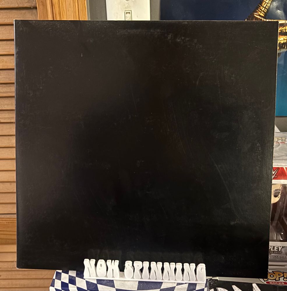The cover of the soundtrack to the film This is Spinal Tap displayed on a stand that says "now spinning".
