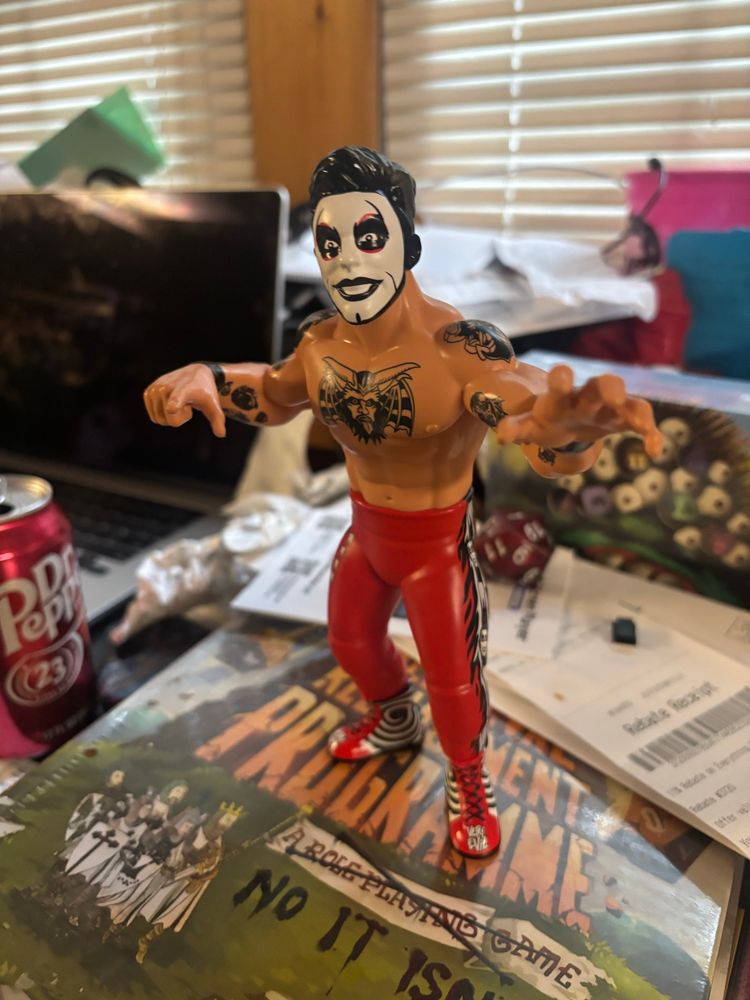 My Danhausen Big Rubber Guy figure displayed on my desk. The desk itself is a little messy.