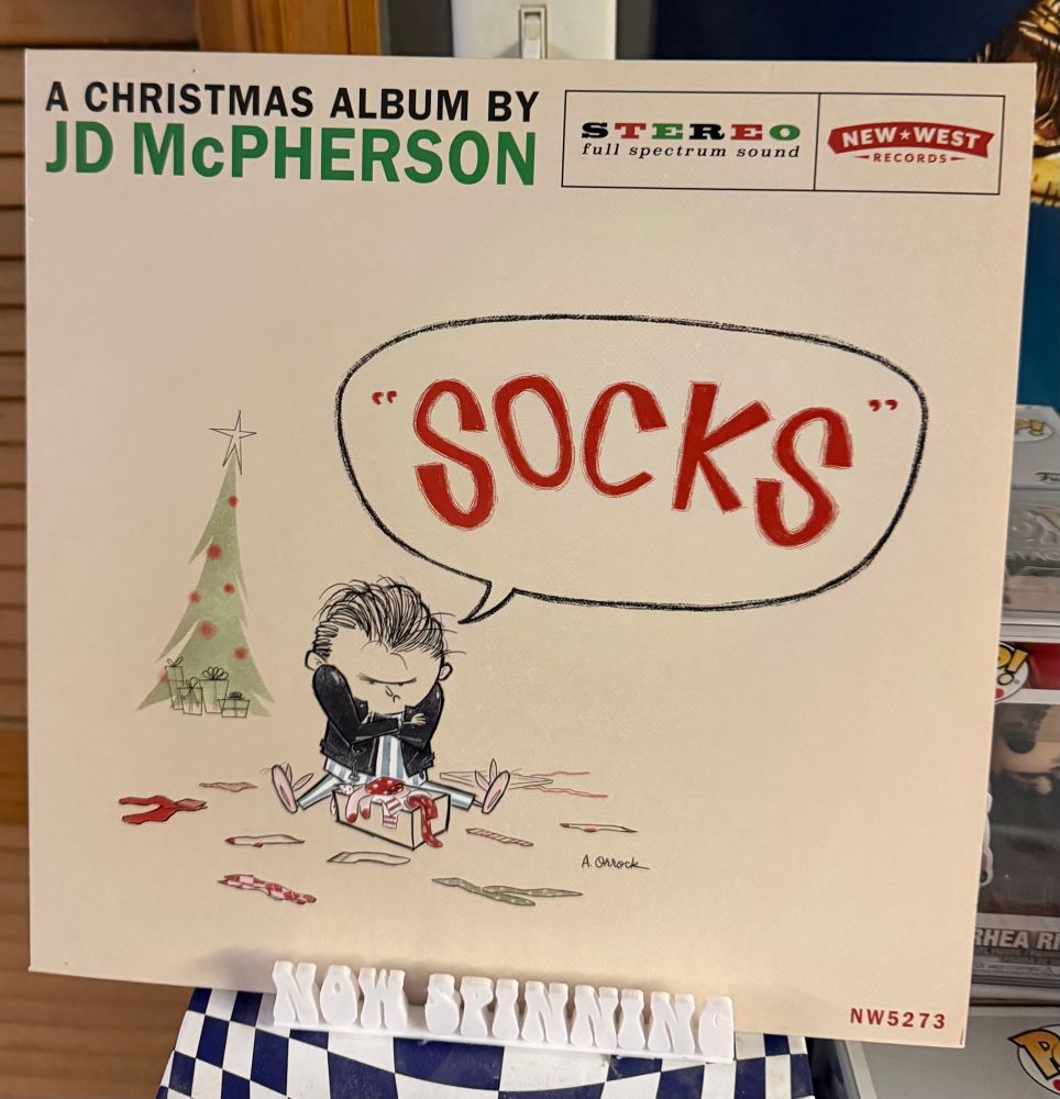 The cover of JD McPherson's album Socks displayed on a stand that says "now spinning".