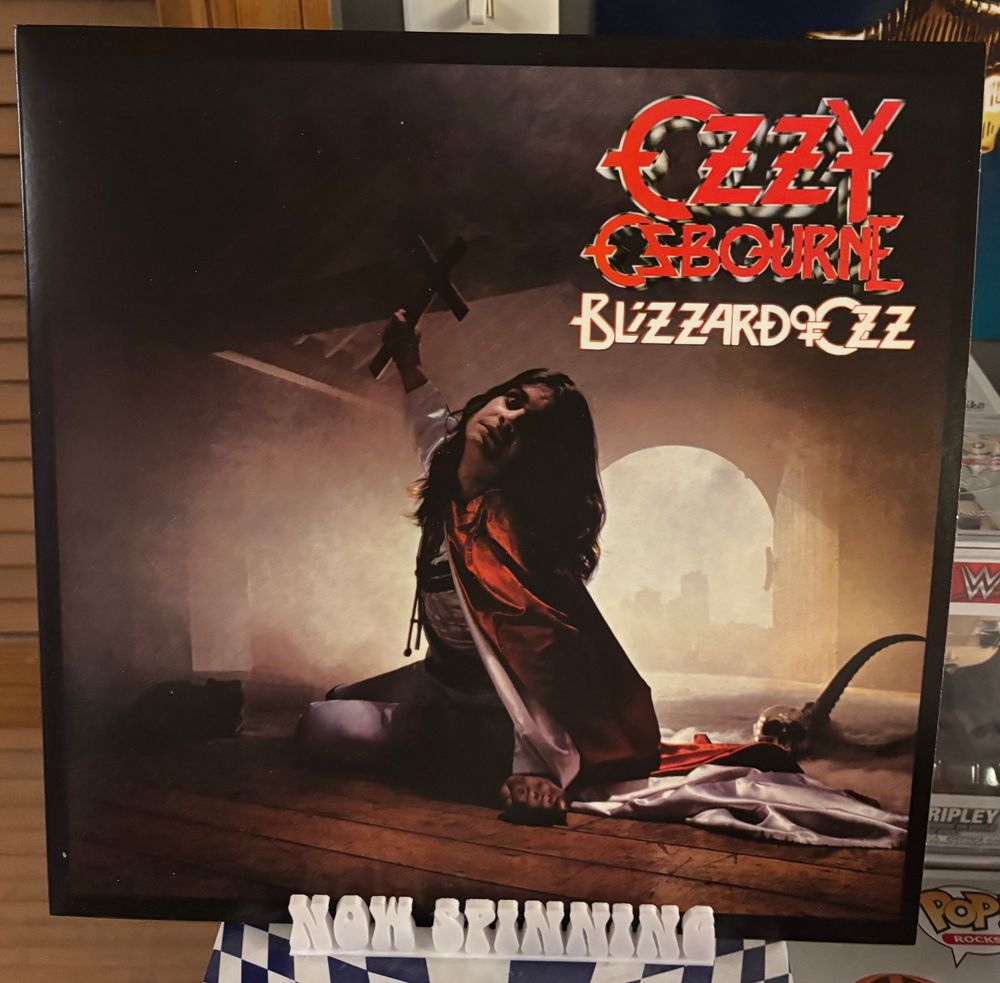 The cover of Ozzy Osbourne's album Blizzard of Ozz displayed on a stand that says "now spinning".