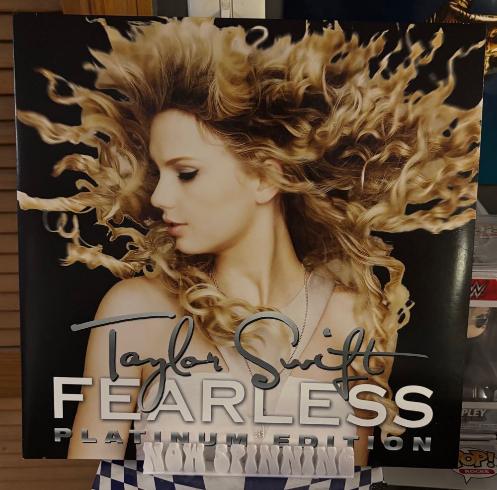 The cover of Taylor Swift's album Fearless (Platinum Edition) displayed on a stand that says "now spinning".