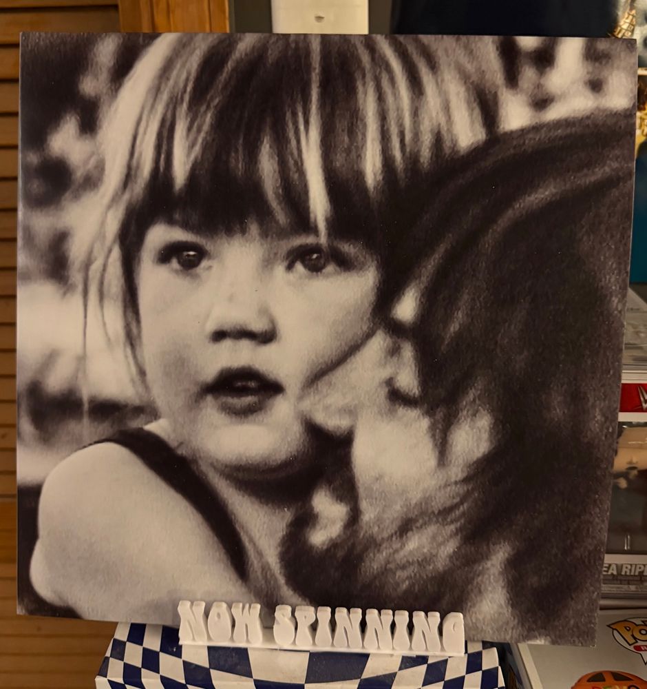 The cover of Tame Impala's album Deadbeat displayed on a stand that says "now spinning".