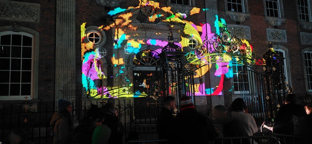 Guild hall lit up by projection allowing visitors to draw on it